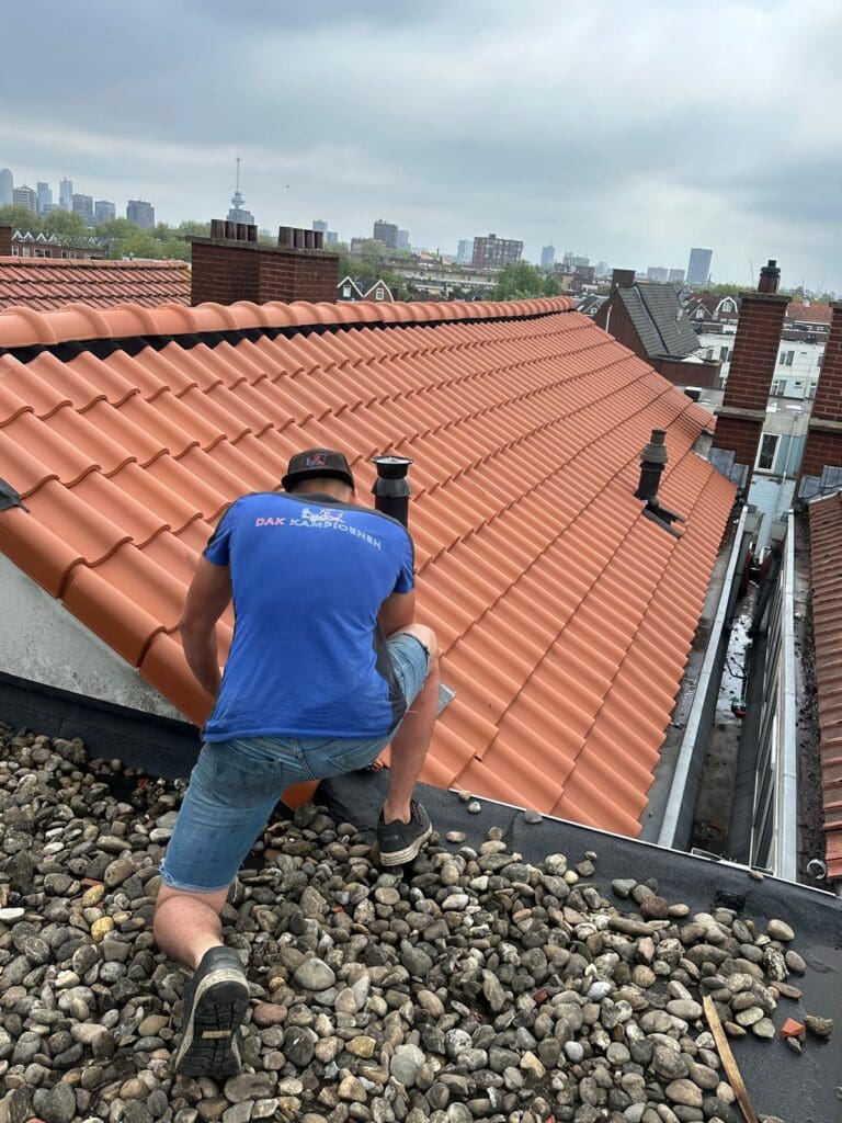 Dakdekker repareert dakpannen op rood pannendak