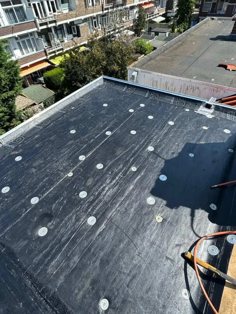 Nieuw geïsoleerd plat dak met bitumen dakbedekking tijdens dakrenovatie in Rotterdam