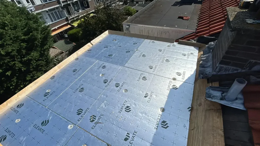 Plaatsing van nieuwe dakisolatie op een plat dak tijdens renovatie in Rotterdam