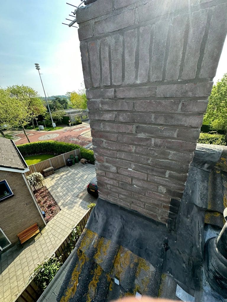 Schoorsteenrenovatie met vernieuwd loodwerk, vernieuwde voegen, gecoate bovenplaat en geïmpregneerde schoorsteen.