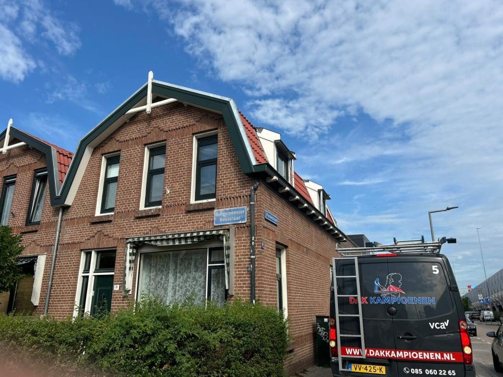 Hellend dak in renovatie met grijze dakfolie, houten tengels en panlatten op een stedelijk gebouw