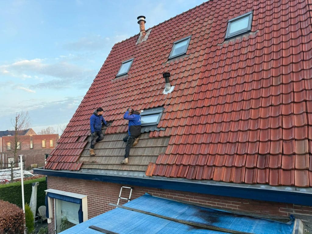 Bovenaanzicht van een woning met rood keramisch pannendak in schilddakvorm, met dakkapellen en schoorsteen
